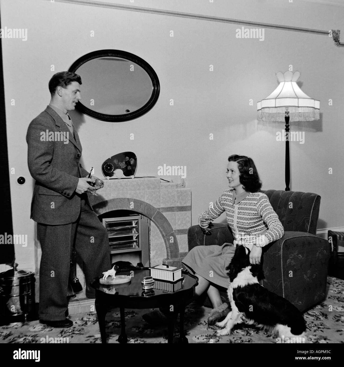 Vecchio VINTAGE IN BIANCO E NERO DI FAMIGLIA fotografia istantanea di coppia sposata nel soggiorno del 1950 circa Foto Stock