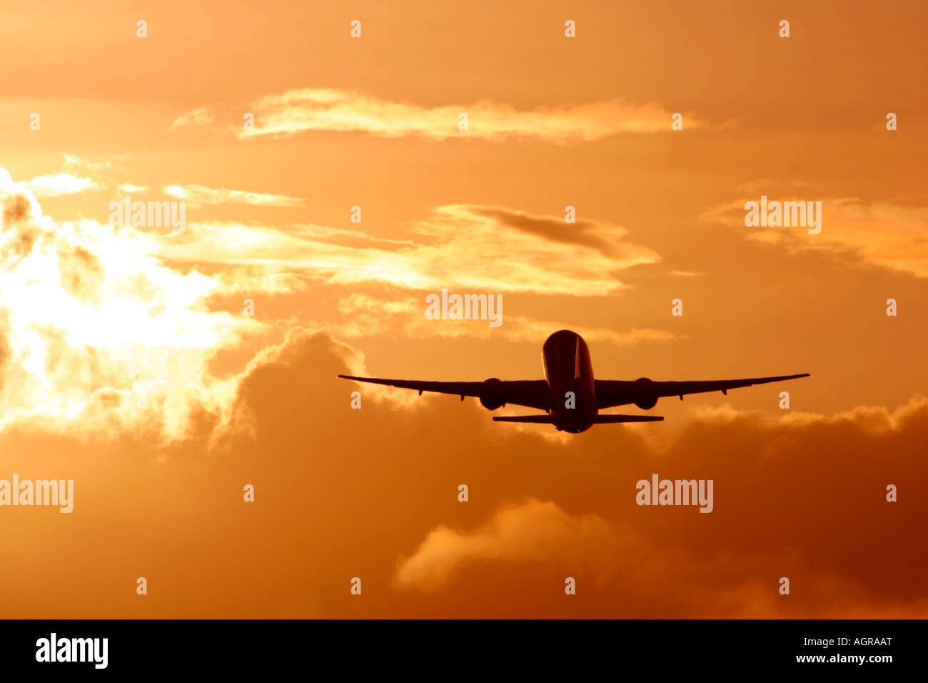 Aereo commerciale durante il volo nelle nuvole e brillante tramonto Foto Stock