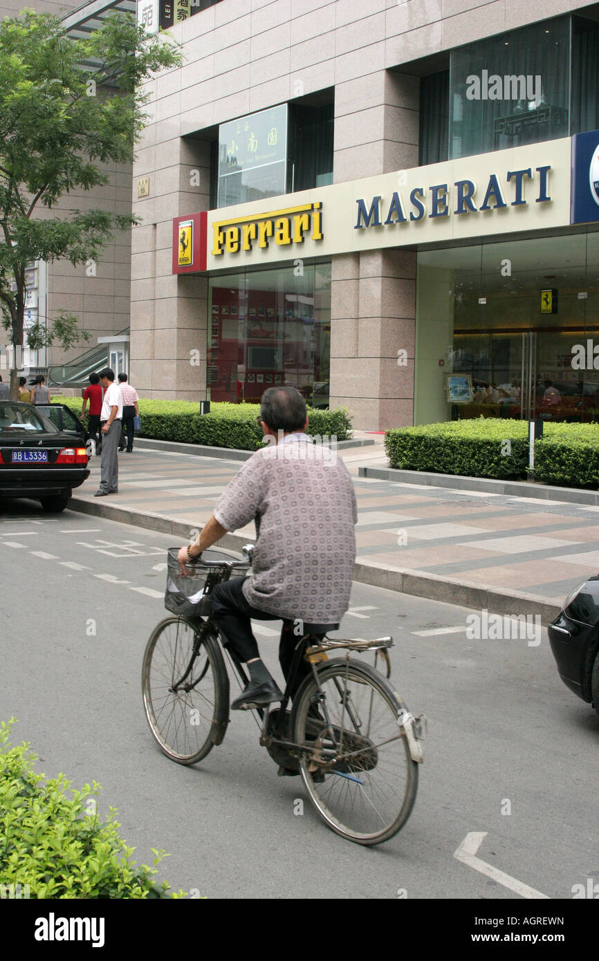 Il contrasto tra l'uomo con una bicicletta e il negozio con vetture di lusso Pechino Cina Agosto 2007 Foto Stock