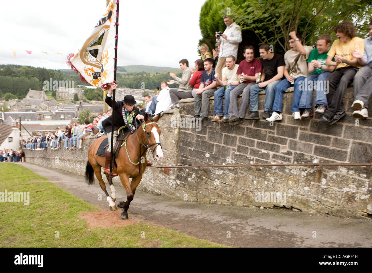 Tradizionale evento scozzese Langholm Equitazione comune cornet la carica sul cavallo fino Kirk Wynd con bandiera Eskdale Scotland Regno Unito Foto Stock