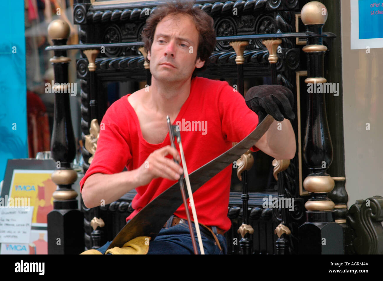 Musicista di strada giocando una sega musicale Foto stock - Alamy