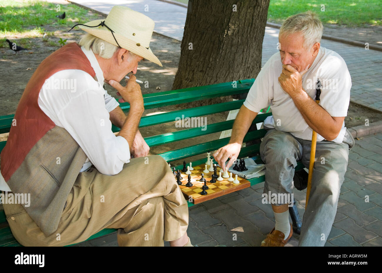 Due uomini anziani giocare a scacchi su una panchina nel parco in Odessa / Ucraina Foto Stock