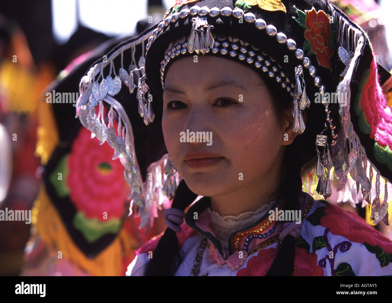 Yi donna in Tanhua, Yunnan, vestito fino al fiore annuale Festival di pinning Foto Stock