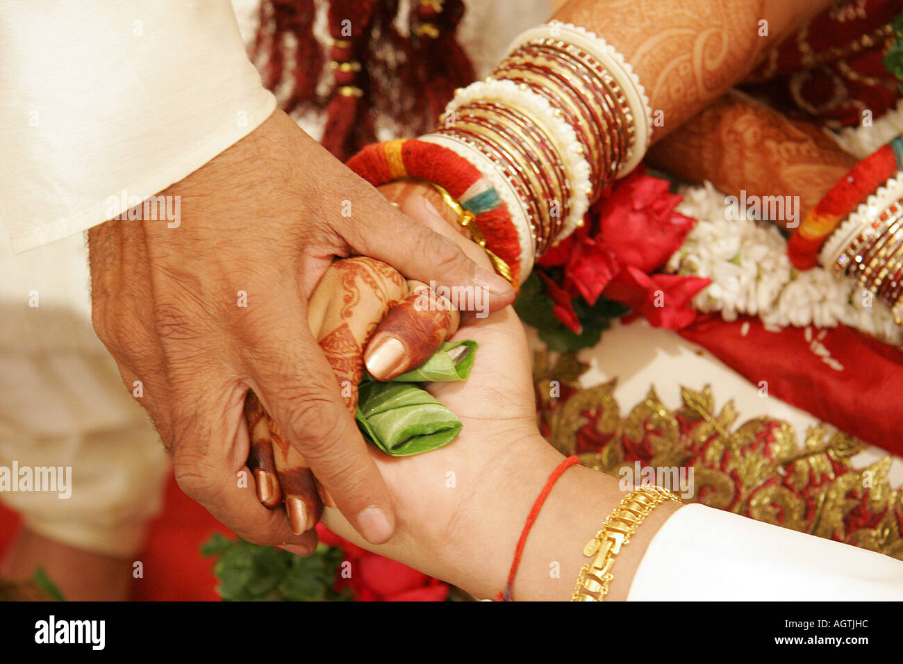 SSK79517 il rituale chiamato Hastmelap essendo eseguita durante la Indian Gujarati wedding brides mano a mano sposi Foto Stock