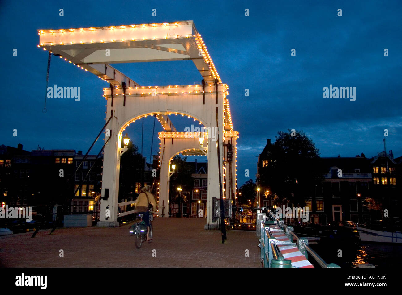 Il famoso Skinny Magere ponte coperto di luci al tramonto sul fiume Amstel di Amsterdam Paesi Bassi Foto Stock