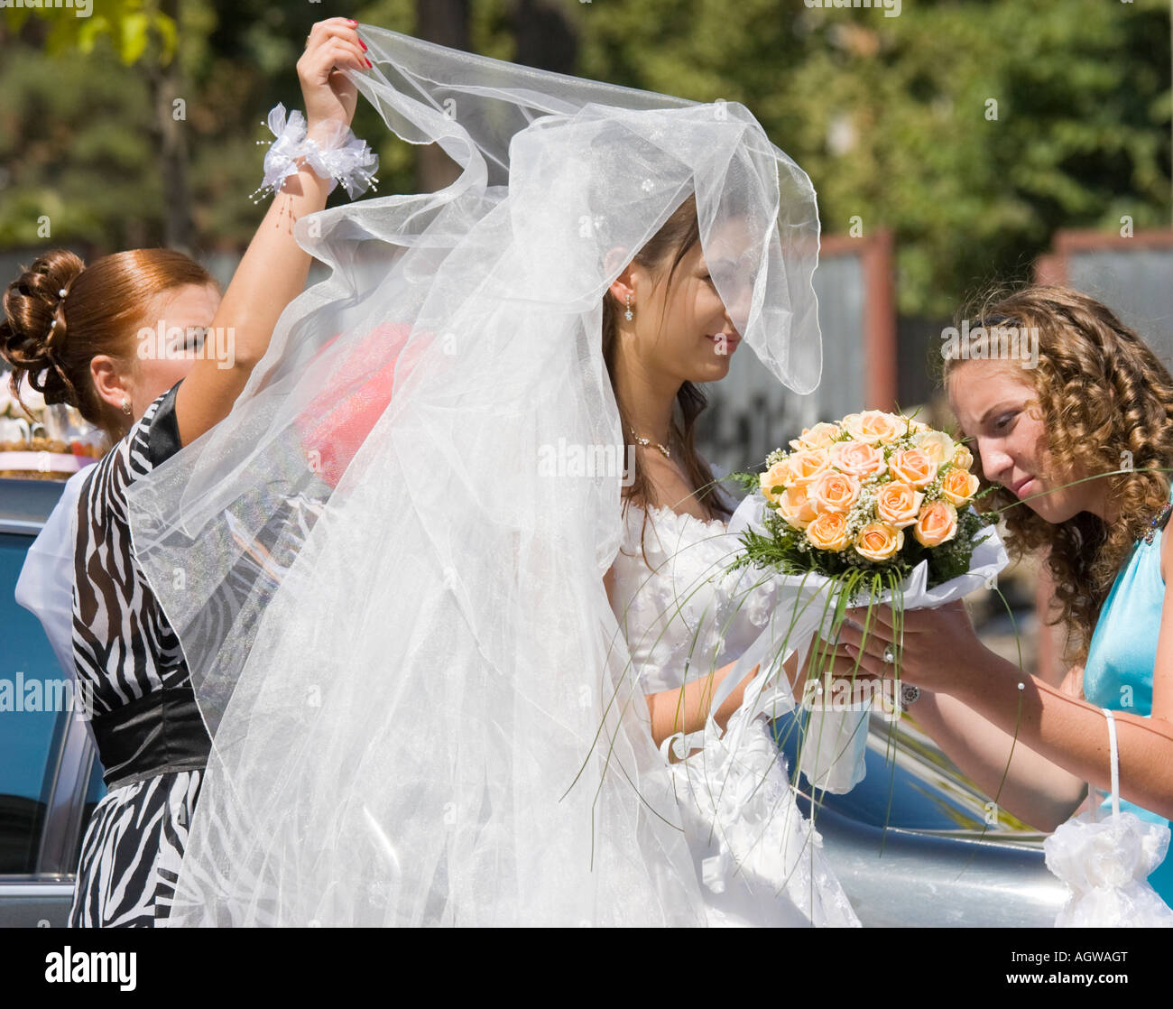 Amici aiutare una sposa con il suo matrimonio abito in Odessa / Ucraina Foto Stock