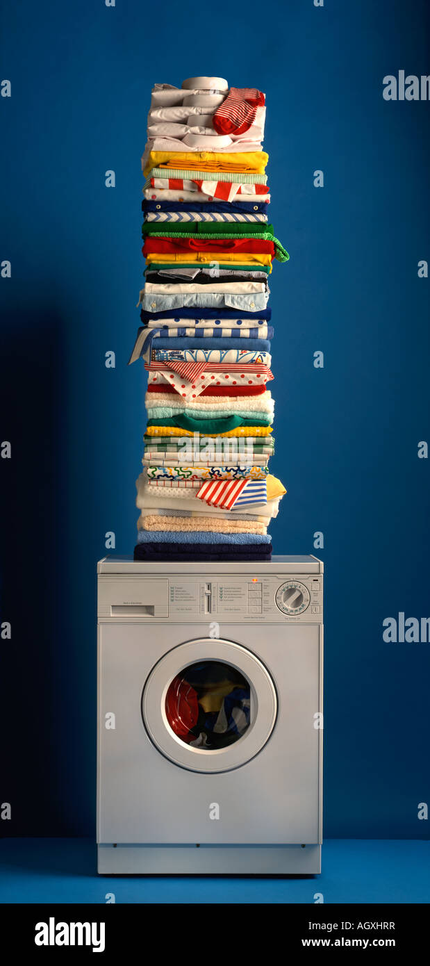 Pila di stirare servizio lavanderia sulla parte superiore della macchina di lavaggio Foto Stock