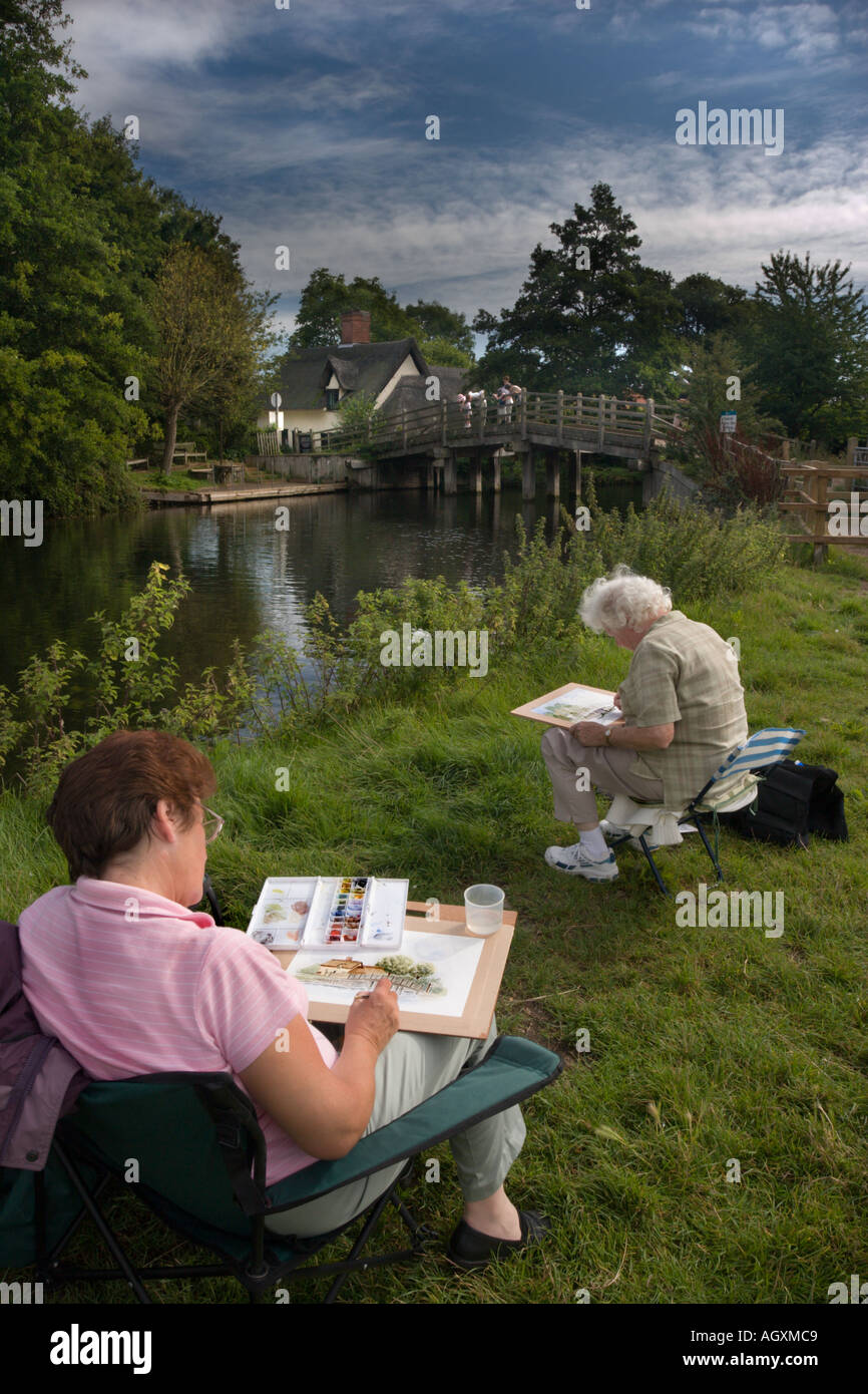 Due artiste pittura il ponte Cottage di scena a Flatford storico nel Suffolk, Inghilterra Foto Stock