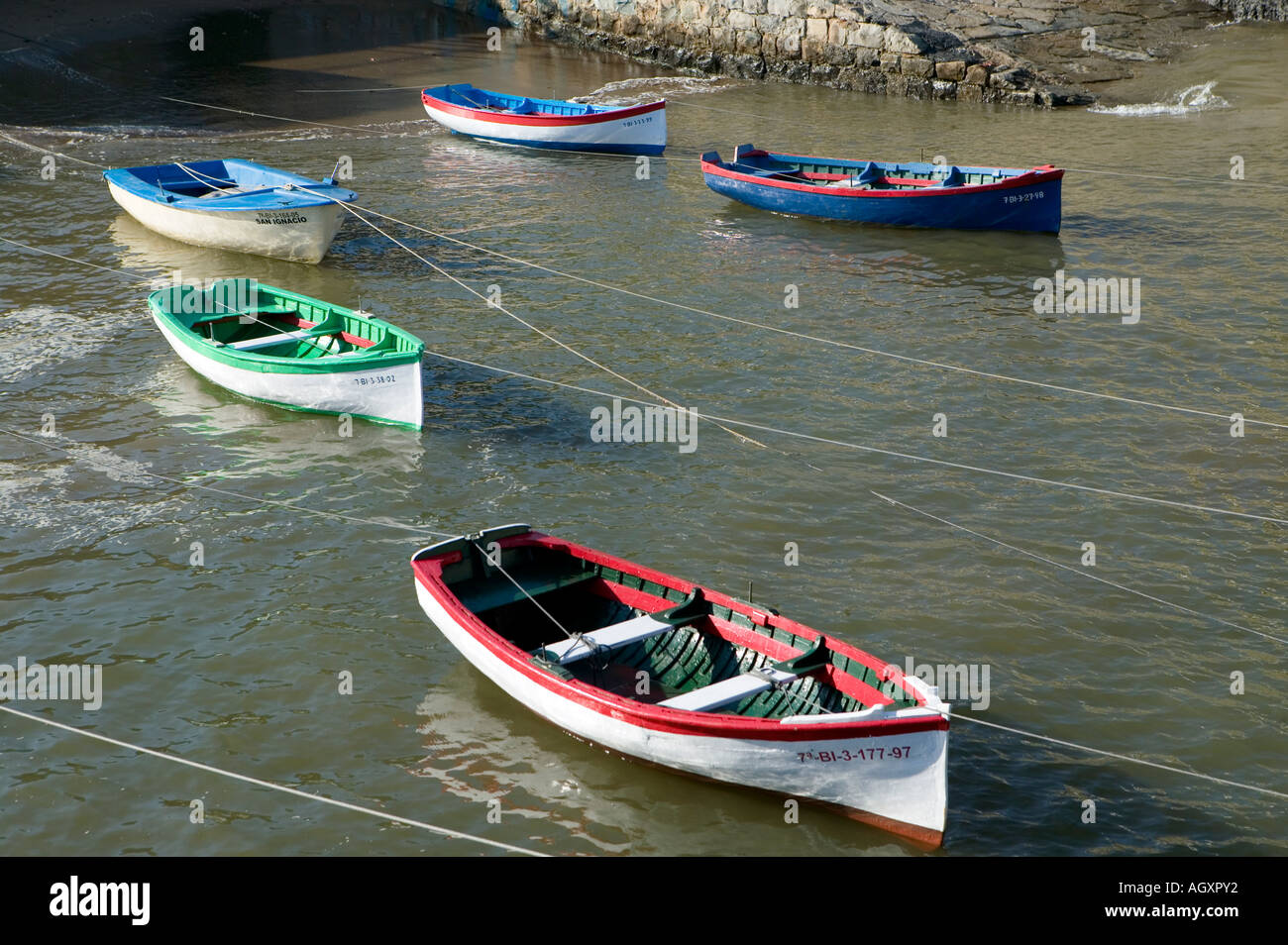 Gruppo di colorate barche a remi ormeggi in Puerto Viejo de Algorta Paese Basco in Spagna Foto Stock