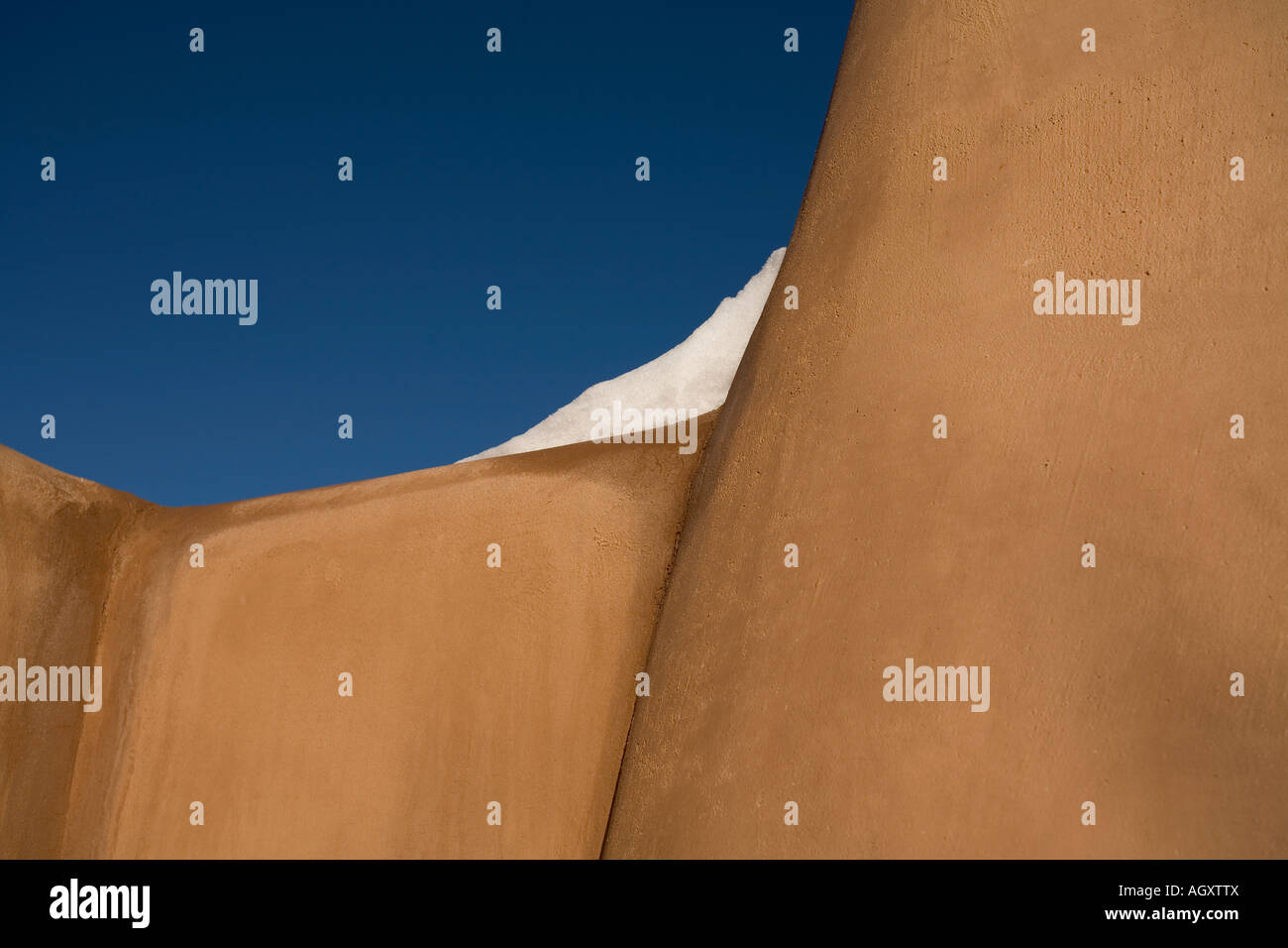 La neve sulla sommità della parete di adobe in Santa Fe, New Mexico USA Foto Stock