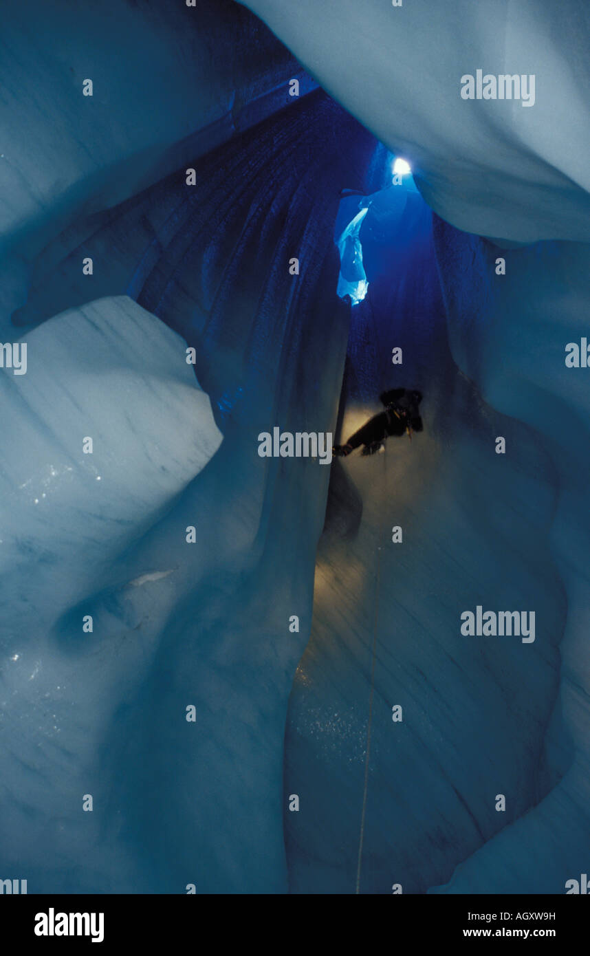 Arrampicatore scendendo in una grotta di ghiaccio, Grand Moulin de la Mer de Glace Chamonix Mont Blanc Foto Stock
