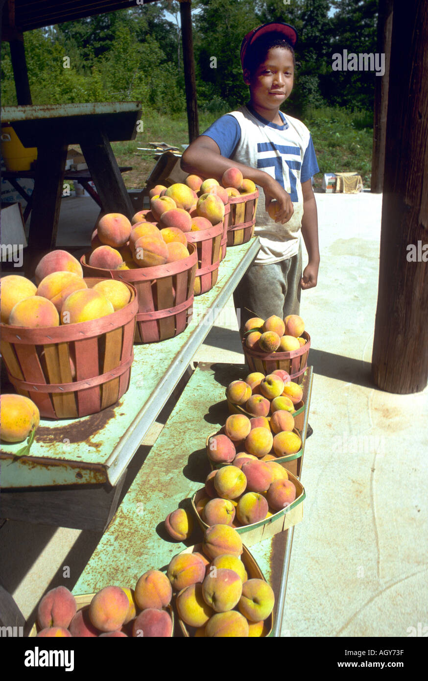 Giovane maschio nero di opere stradali famiglia peach stand Georgia Foto Stock