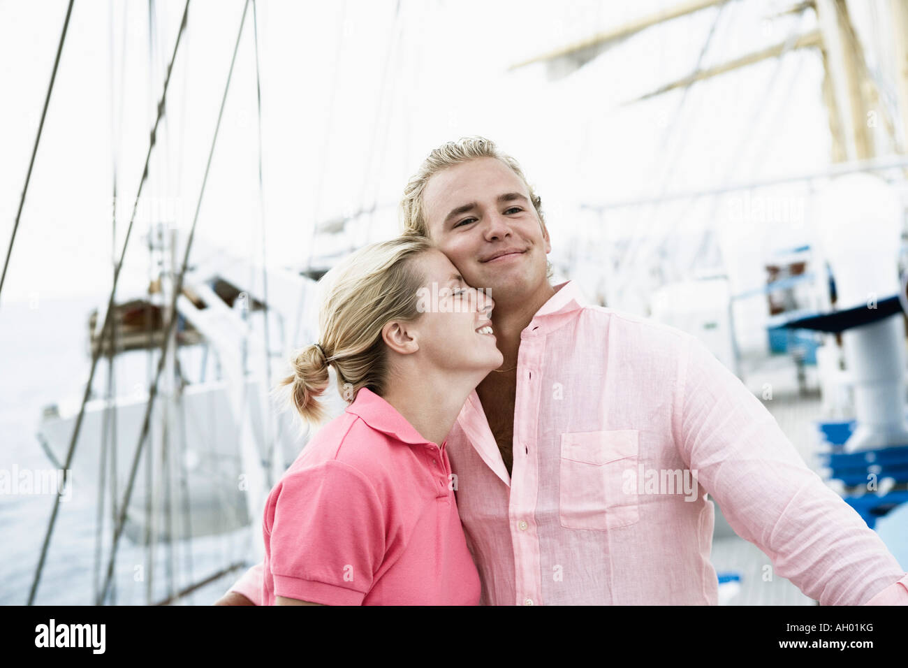 Coppia giovane che abbraccia ogni altra e sorridente Foto Stock