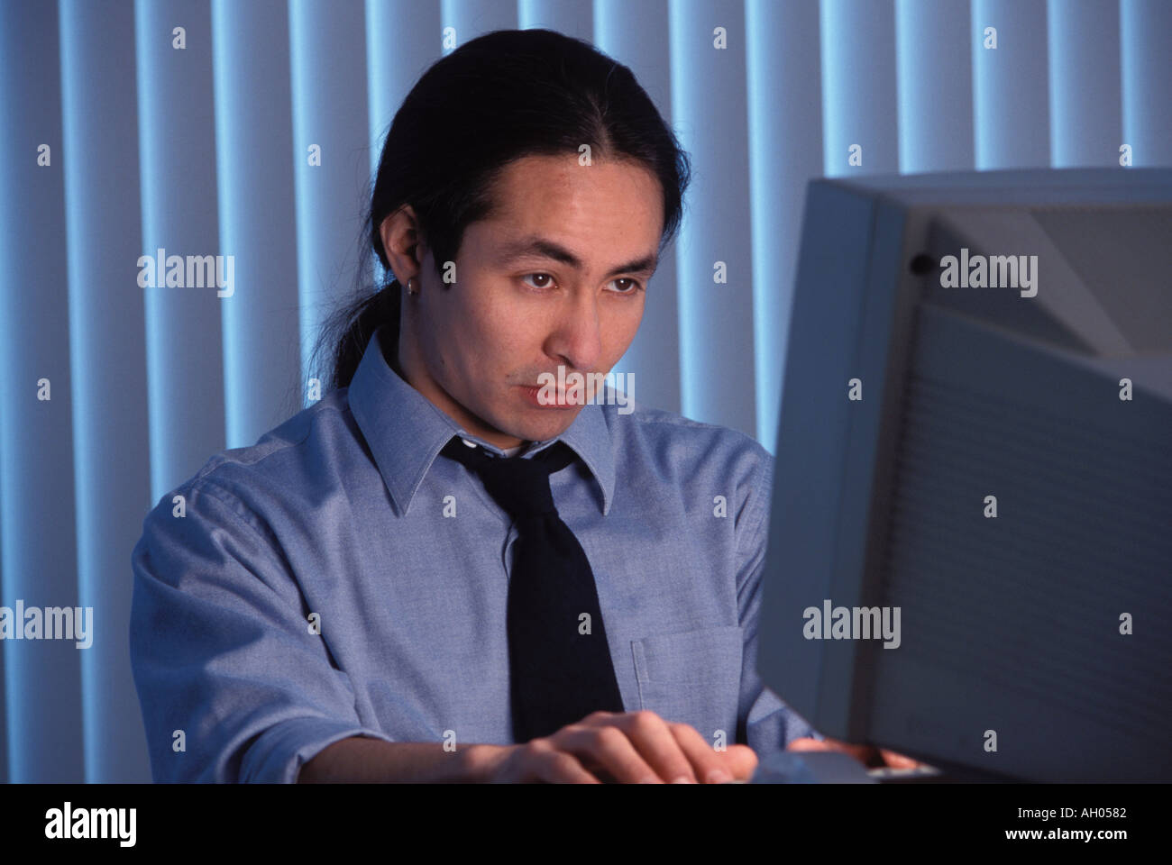 L'uomo lavora fino a tardi in ufficio Foto Stock