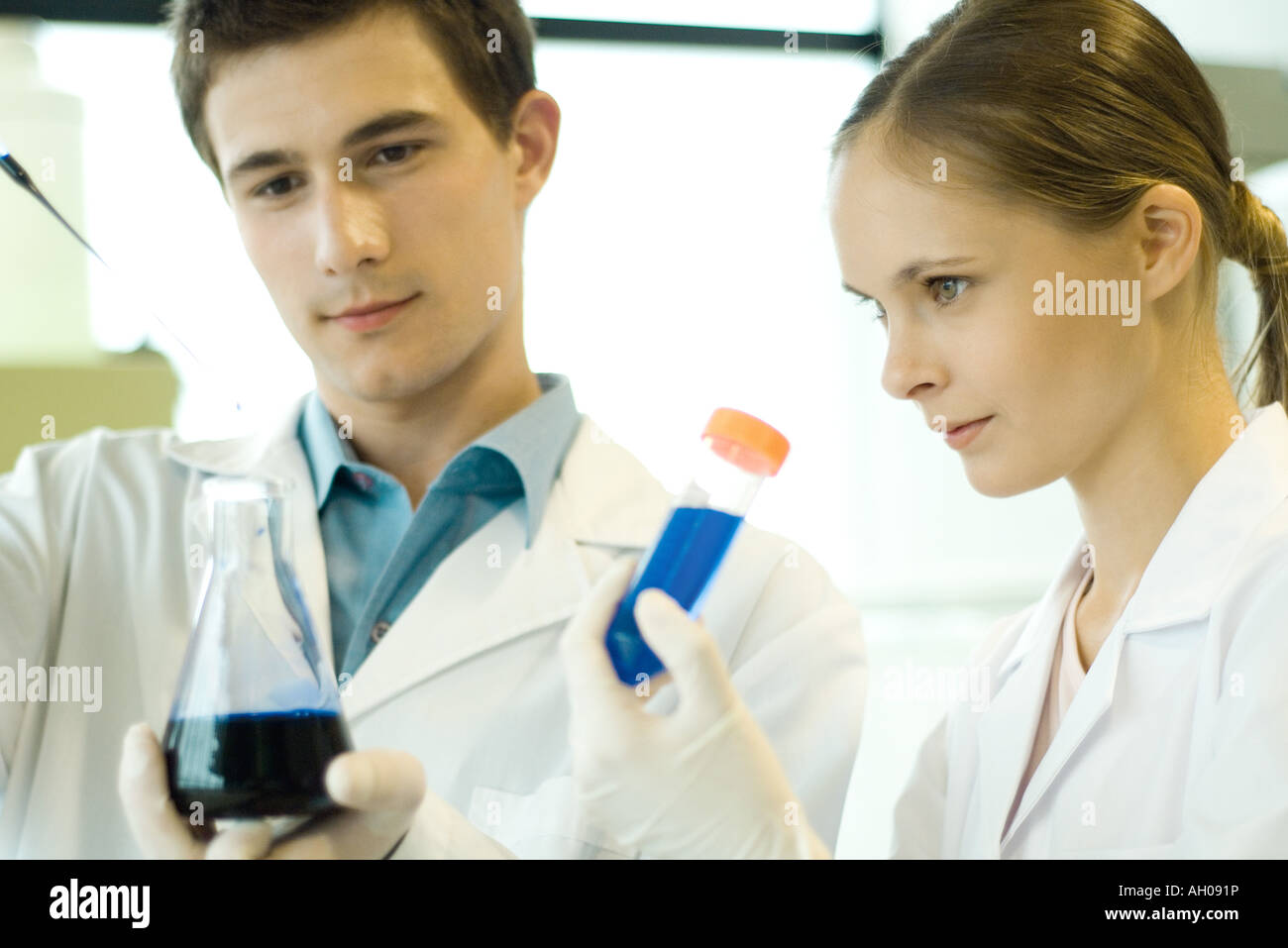Giovane maschio e femmina scienziati tenendo il tubo di prova e il pallone Foto Stock