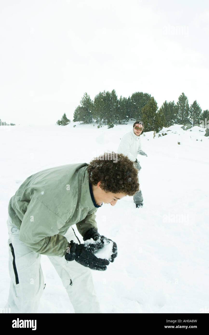 Giovani amici di lotta con le palle di neve nella neve Foto Stock