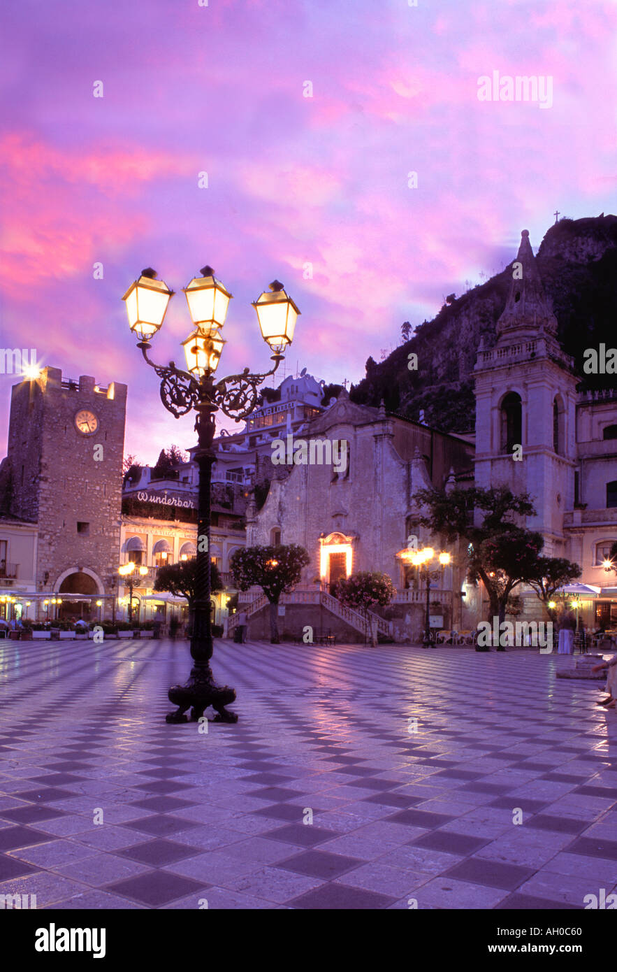 Italia Sicilia Taormina centrale Piazza al tramonto con la cima della montagna monastero che si affaccia sulla città Foto Stock