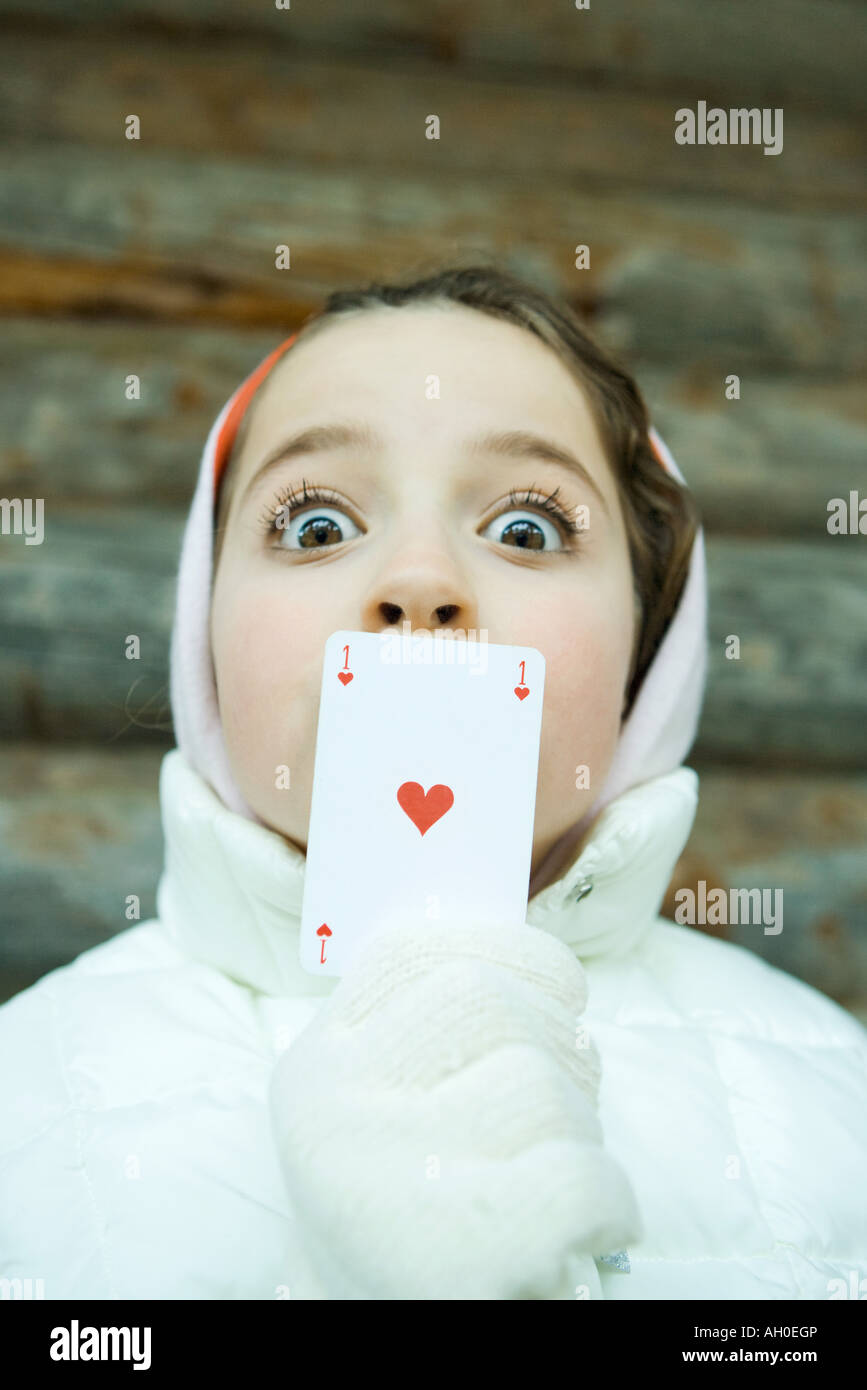 Ragazza con scheda al di sopra della bocca, vestito in abiti invernali, guardando la telecamera, occhi grandi Foto Stock