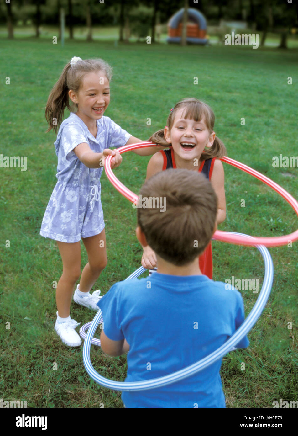Ragazzo e le ragazze a giocare con hula hop cerchi Foto Stock