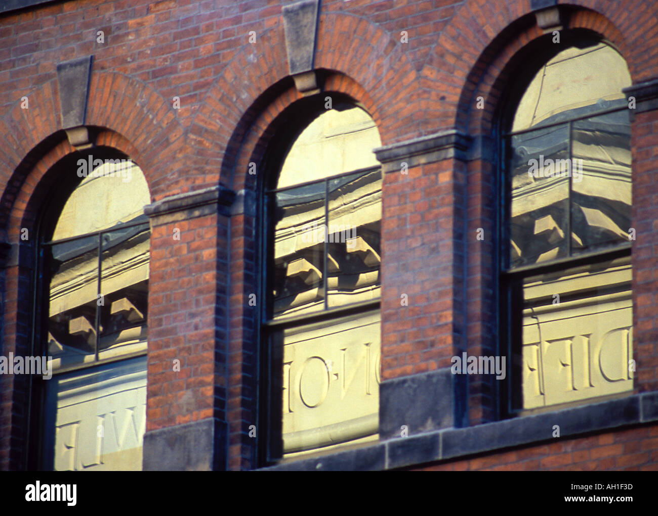 Dettaglio dall'Athenaeum Princess Street Manchester da Charles Barry riflessa nelle finestre di un edificio vittoriano Foto Stock