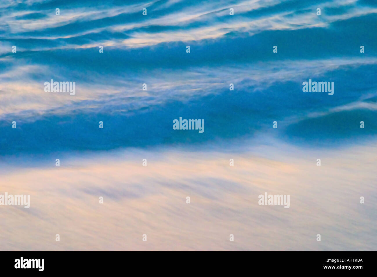 Close up lunga esposizione della piccola e bella blu di onde che si infrangono sulla riva del mare di sunrise Foto Stock