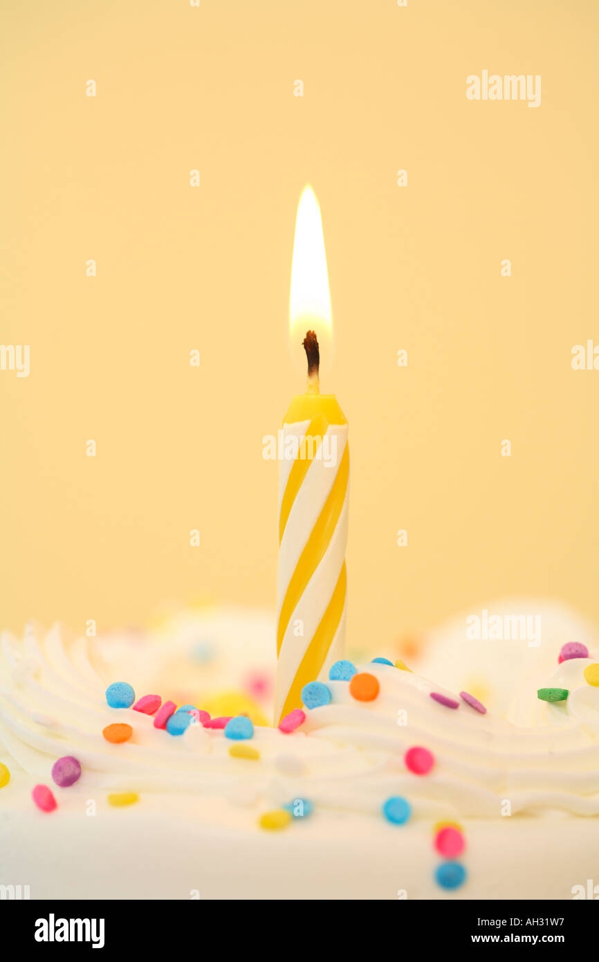 Singola candela di compleanno con sfondo giallo Foto Stock