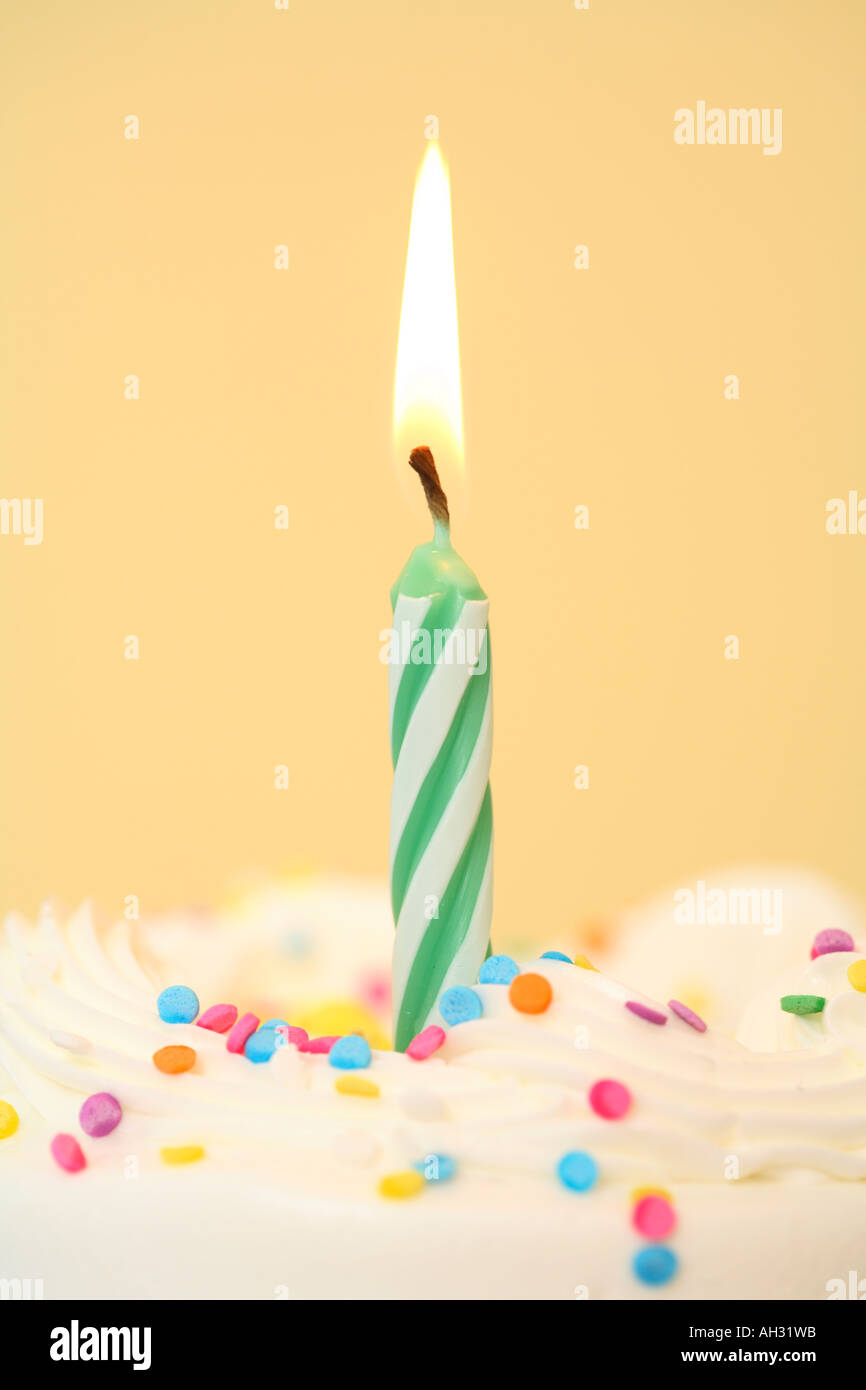 Singola candela di compleanno con sfondo giallo Foto Stock