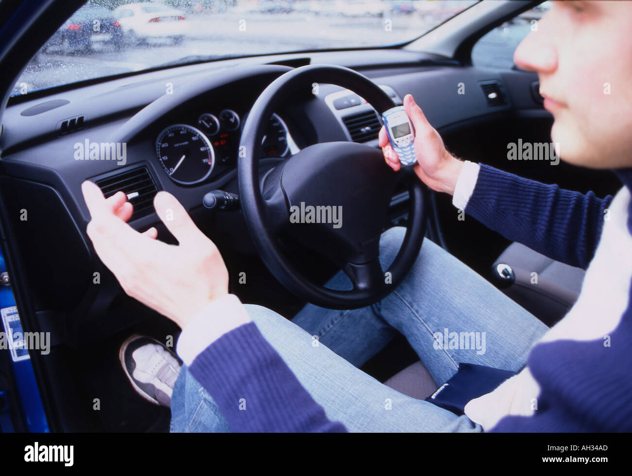 Uomo con telefono cellulare in un'automobile Foto Stock