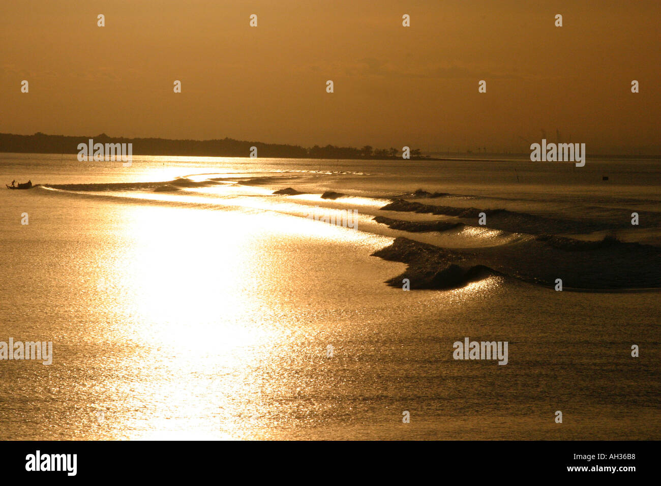 Buona mattina Vietnam,la mattina presto si riflette in golden onde sul fiume Mekong Delta vicino a Saigon Vietnam Foto Stock