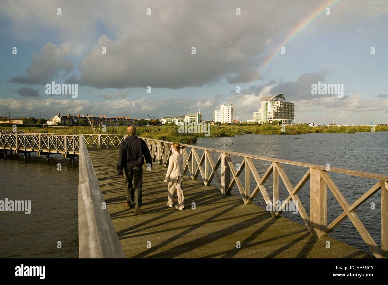 Uomo e bambino sul lungomare di arcobaleno su St David s Hotel e chiesa norvegese per la Baia di Cardiff Wales UK Foto Stock