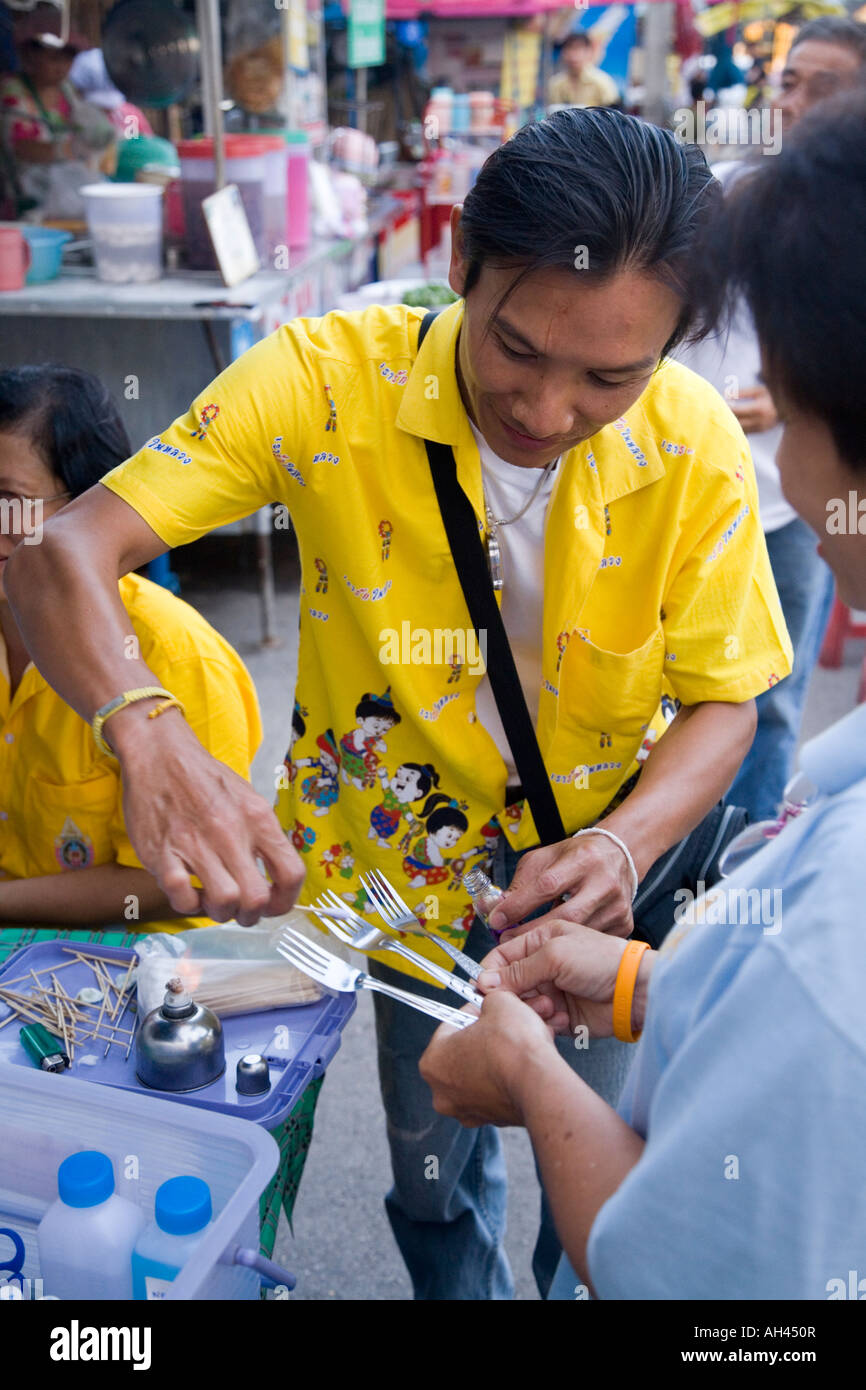 Il funzionario di ispezione alimentare della sanità pubblica prova le attrezzature di ristorazione utilizzate dai venditori di alimenti nel mercato alimentare di Lampang, Thailandia. Foto Stock