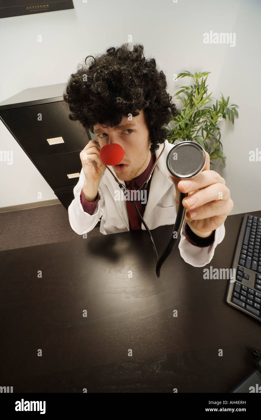 Medico con clown naso e capelli Foto Stock