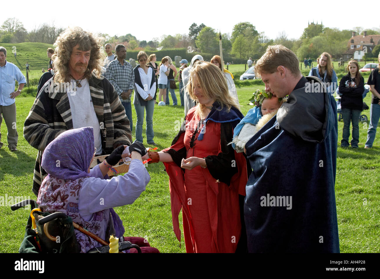 Pagani celebrando un wiccaning baby Bambino benedicente come la cerimonia di battesimo ad anello di Avebury Stone Circle durante druidic Beltain festival Foto Stock