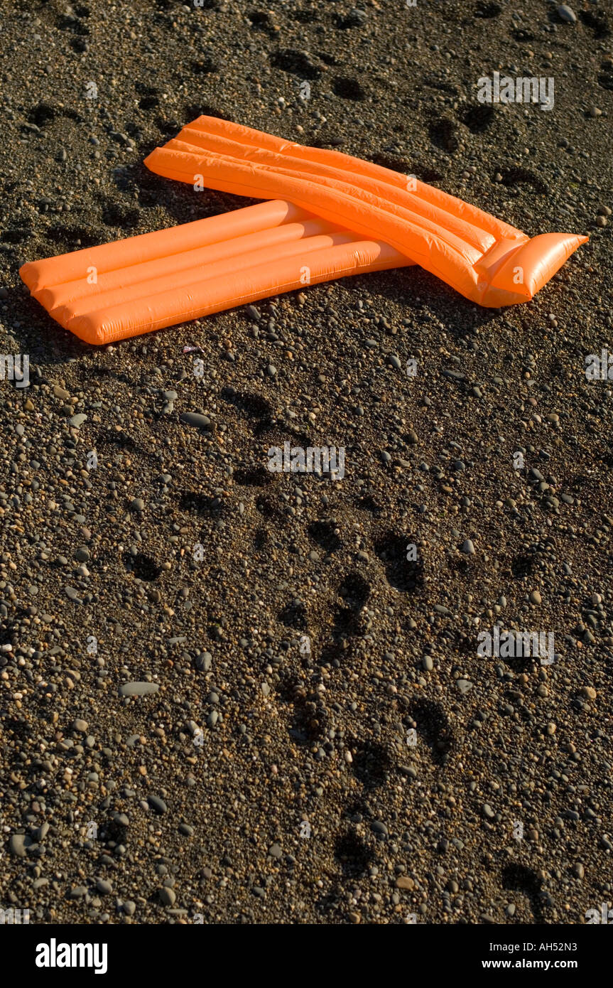 Due orange gonfiabile materassi di lilo sulla spiaggia Aberystwyth Ceredigion nel Galles Foto Stock