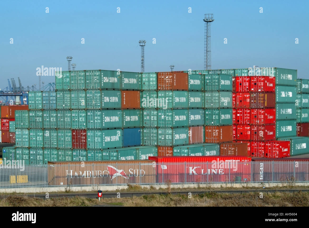 Pile alte di rosso verde immagazzinato contenitori di spedizione molti appartenenti alla linea di spedizione cinese che fa il commercio del contenitore al porto di Felixstowe Suffolk Inghilterra UK Foto Stock