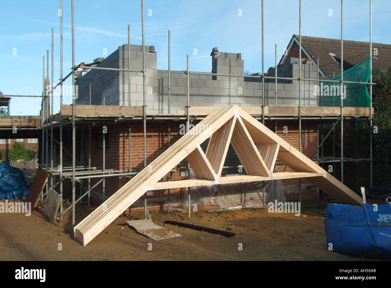 Capriate consegnato a casa indipendente sito di costruzione appoggiata contro il ponteggio con primo piano parete di cavità blockwork in costruzione England Regno Unito Foto Stock