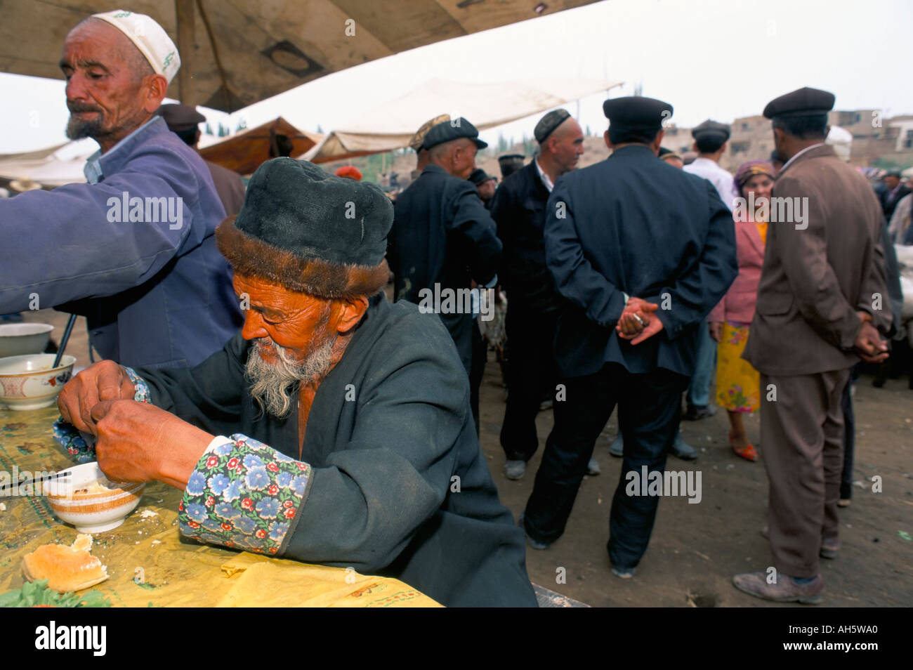 Vecchio Uighur man a stallo alimentare mercato domenicale Kashi Xinjiang Cina Asia Foto Stock