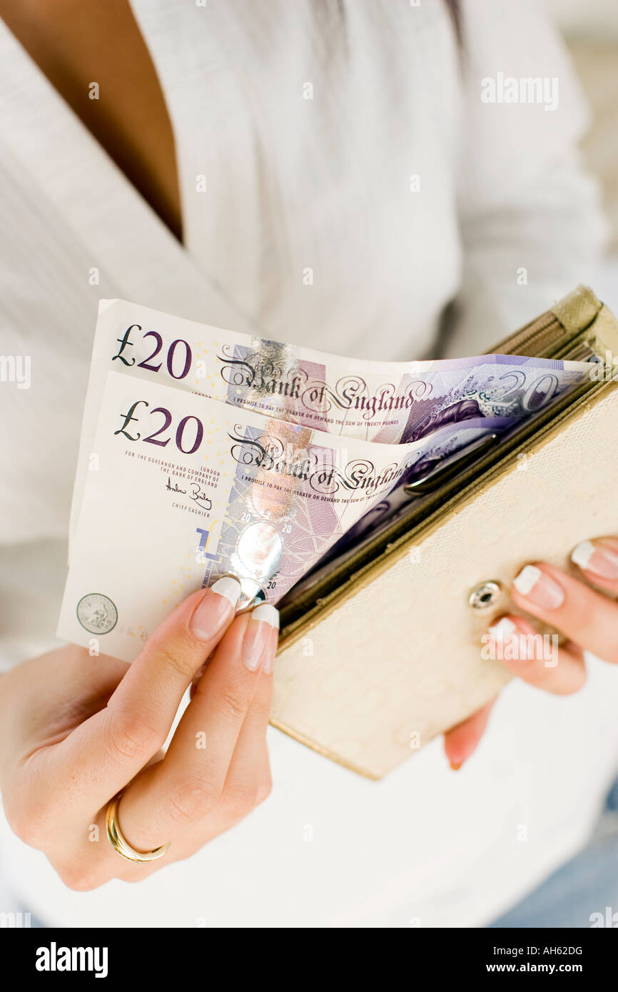 Donna con 20 pound note in borsa Foto Stock