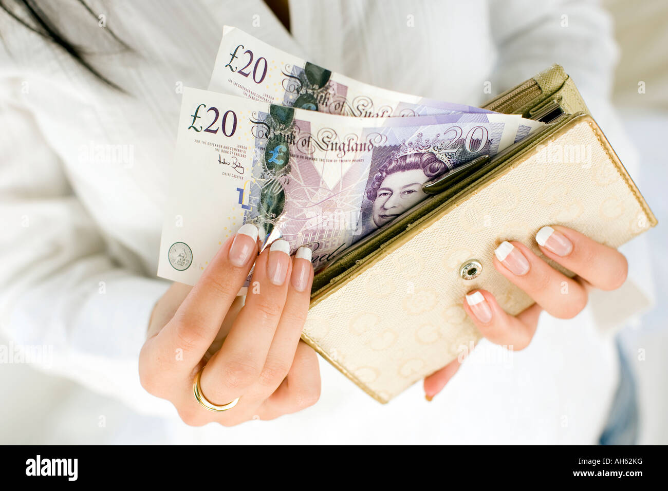 Donna con 20 pound note in borsa Foto Stock