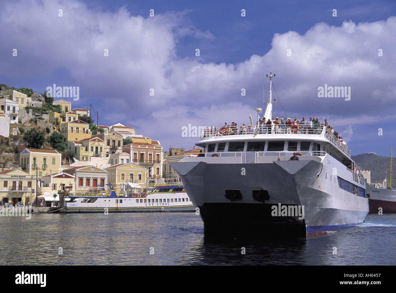 Catamarano con i turisti che arrivano sull'isola greca di Symi Foto Stock