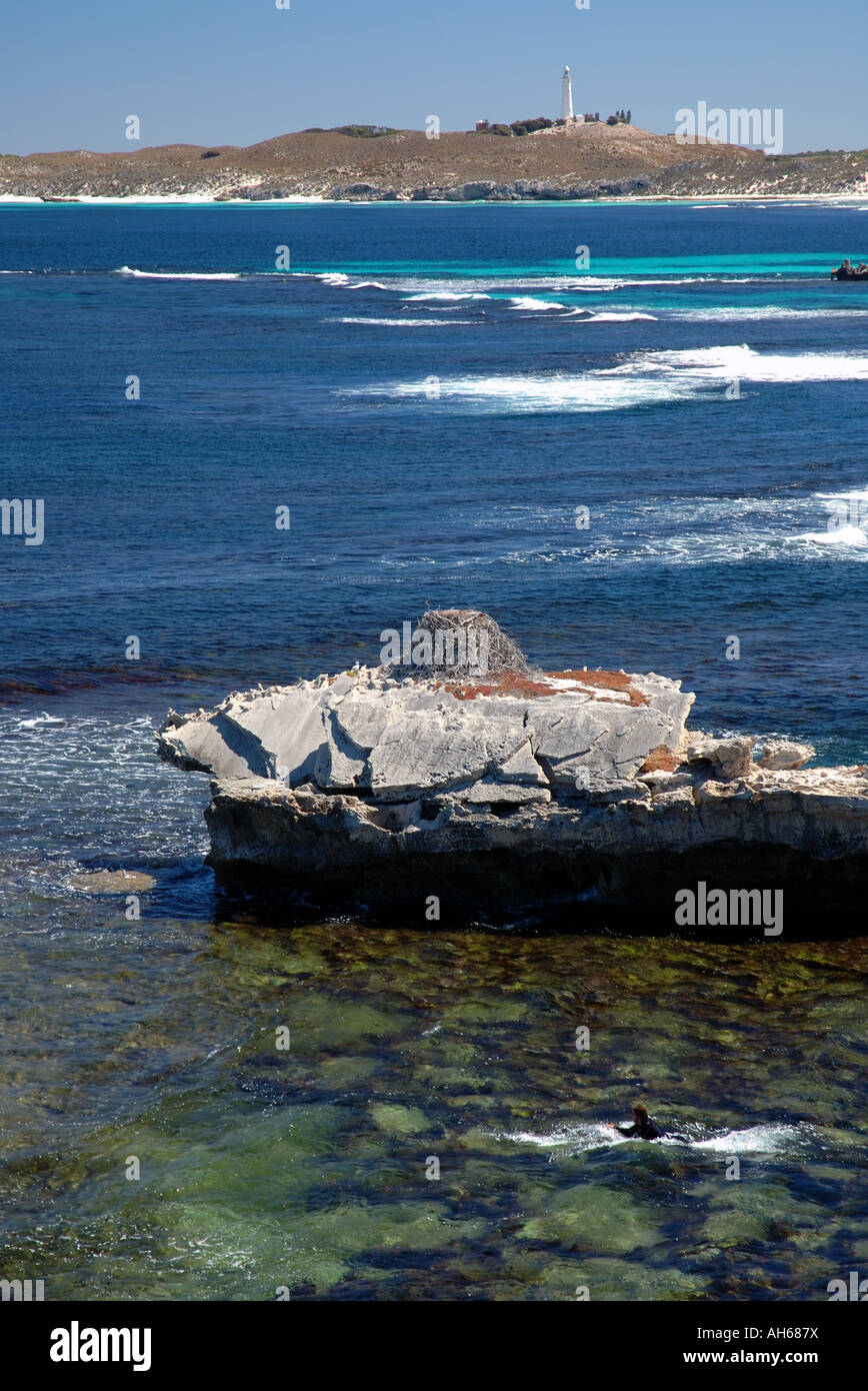 Surfer paddling out ai polli (famoso surf spot) vicino alla baia di salmone, con Wadjemup faro in background Foto Stock