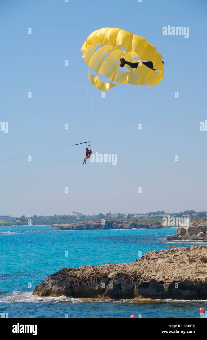 Parapendio oltre il promontorio roccioso off Nissi spiaggia nei pressi di Ayia Napa sull'isola Mediterranea di Cipro UE Foto Stock