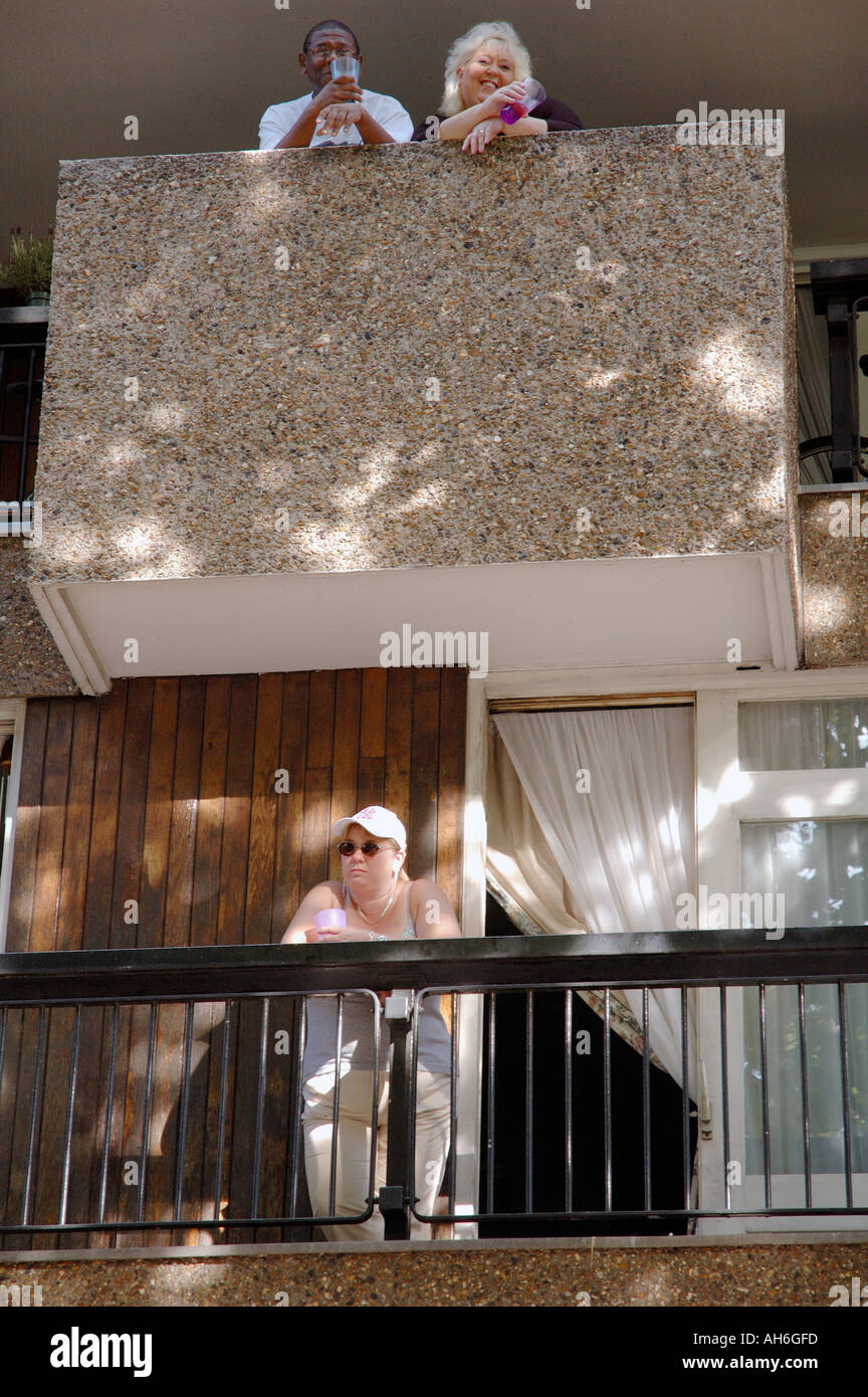 Casa consiglio estates con tenents seduti sul balcone in area interna della città di West London. Foto Stock