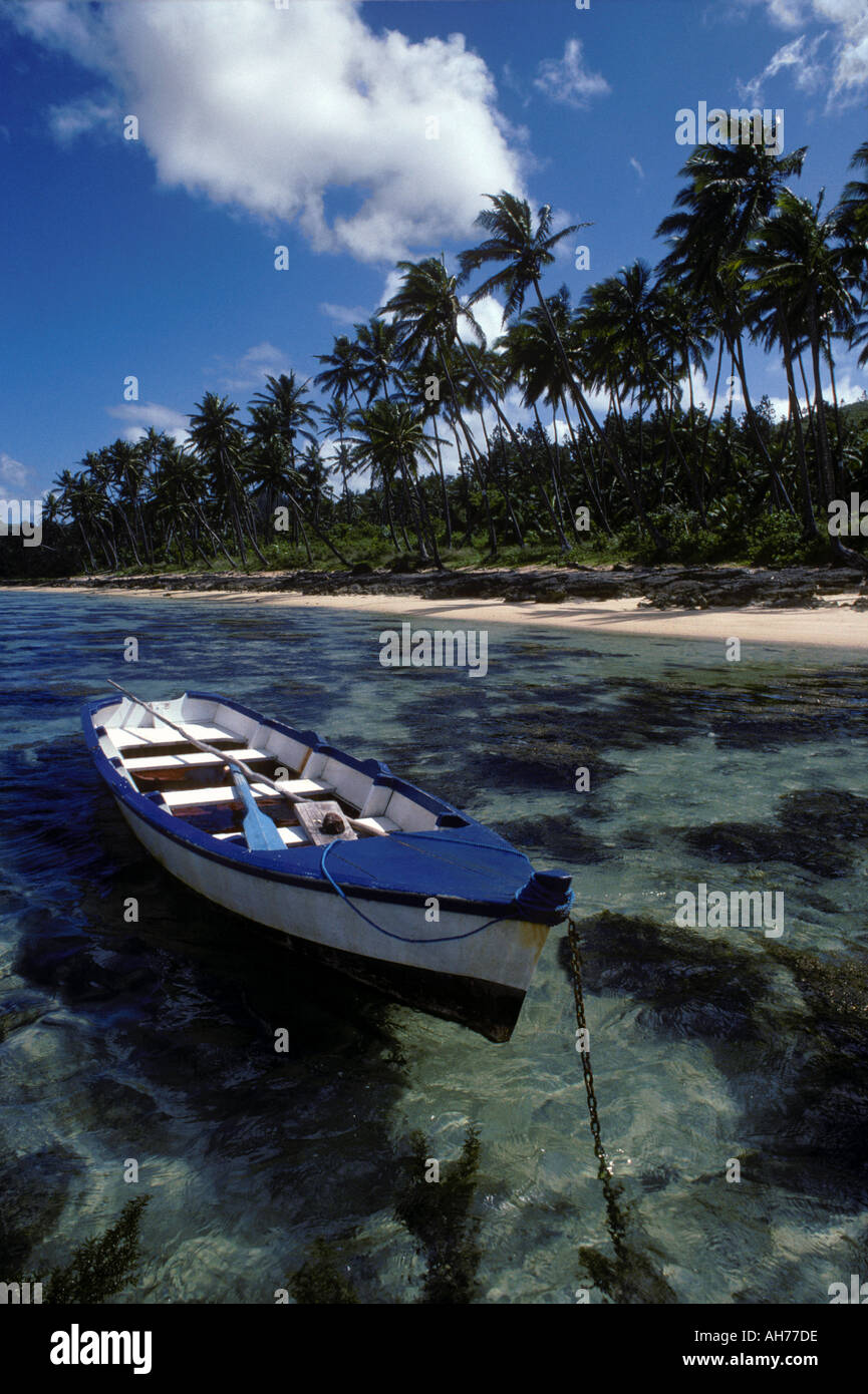Barca da pesca di acque chiare di spiaggia di sabbia bianca, palme tropicali e cielo blu della Riviera del Corallo a Viti Levu Figi Foto Stock
