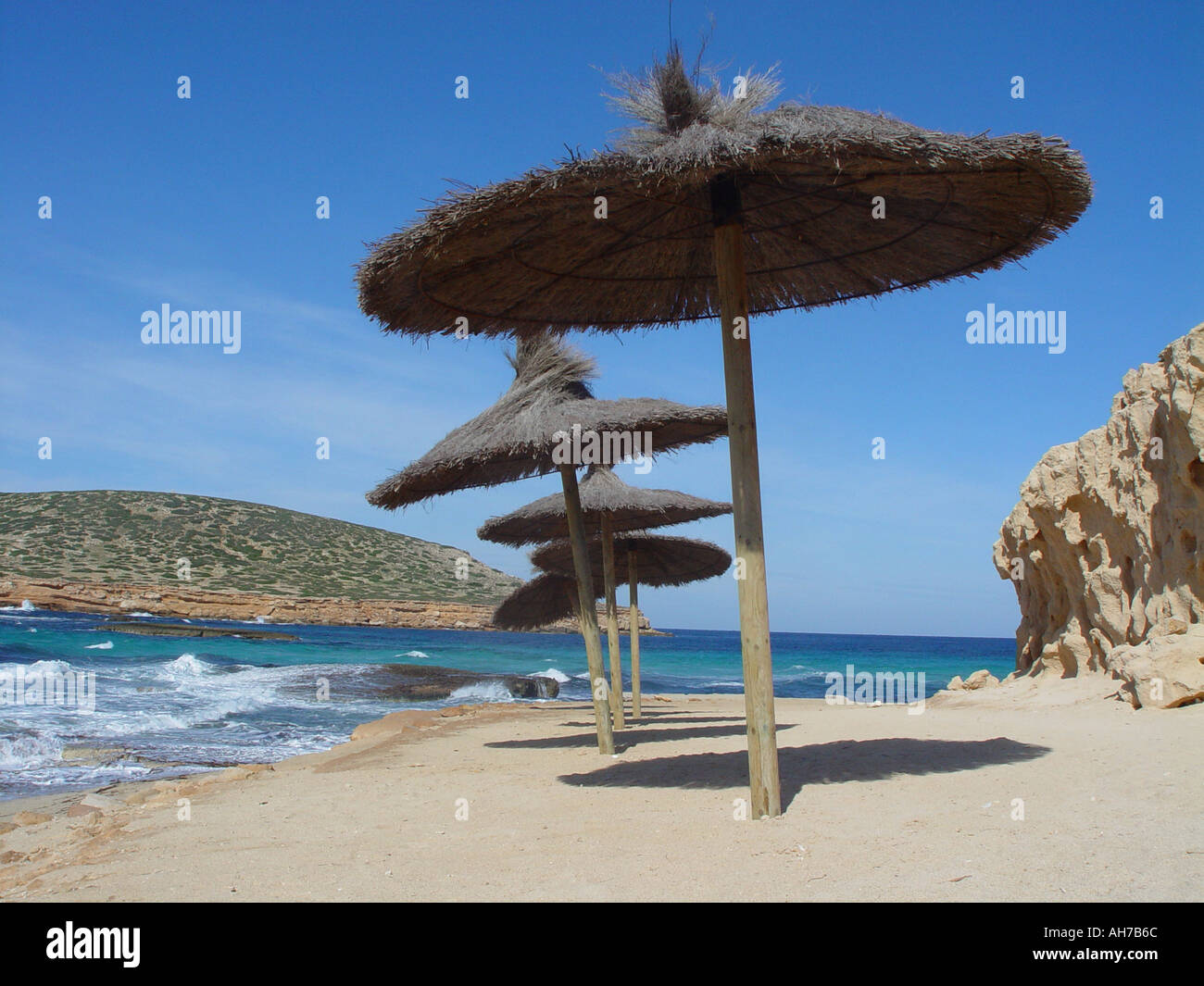 Ombrellone sulla spiaggia mediterranea isola delle Baleari di Ibiza spagna nelle calde giornate di sole con cielo blu Foto Stock