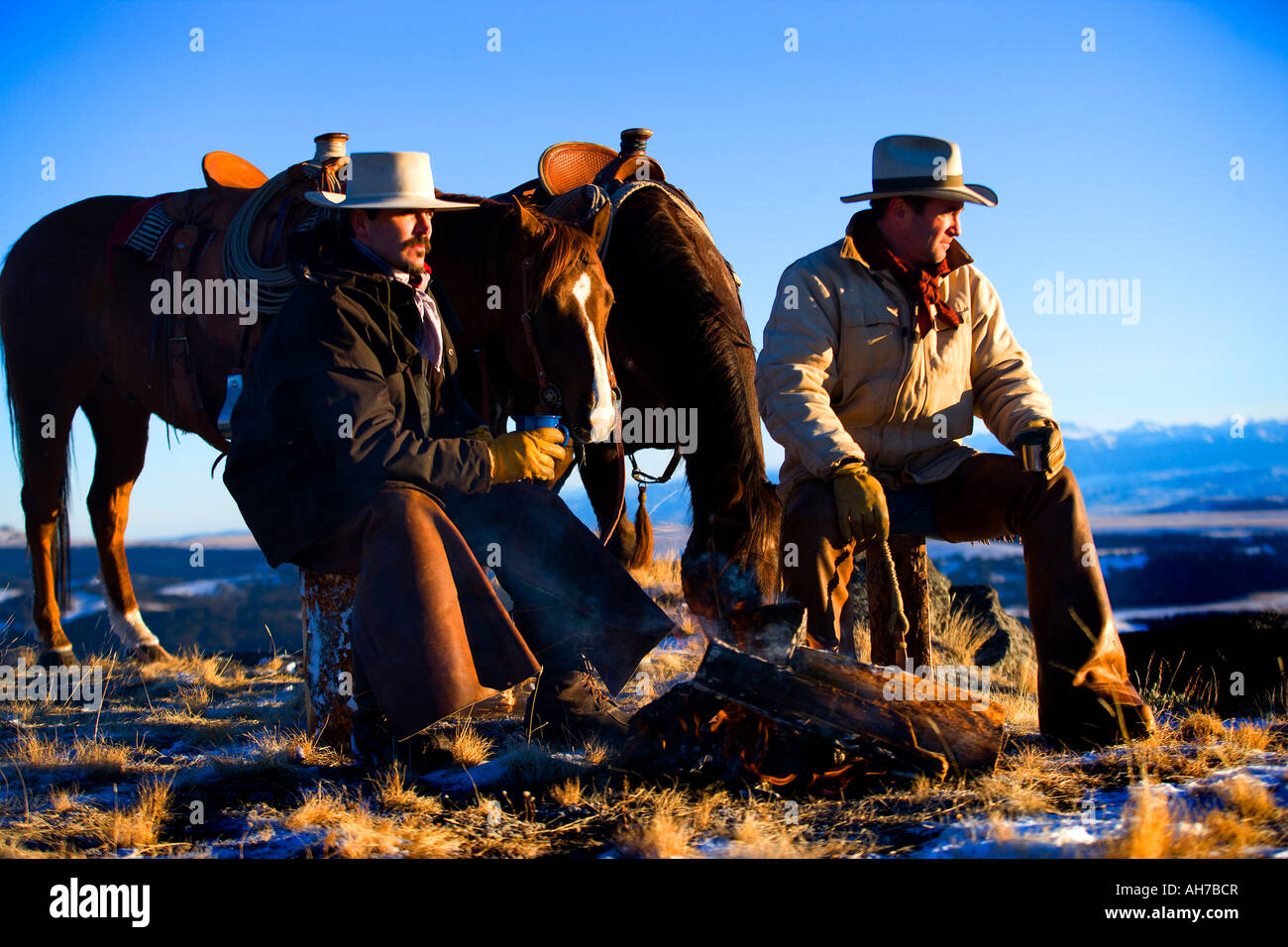 Due uomini seduti davanti a un falò Foto Stock