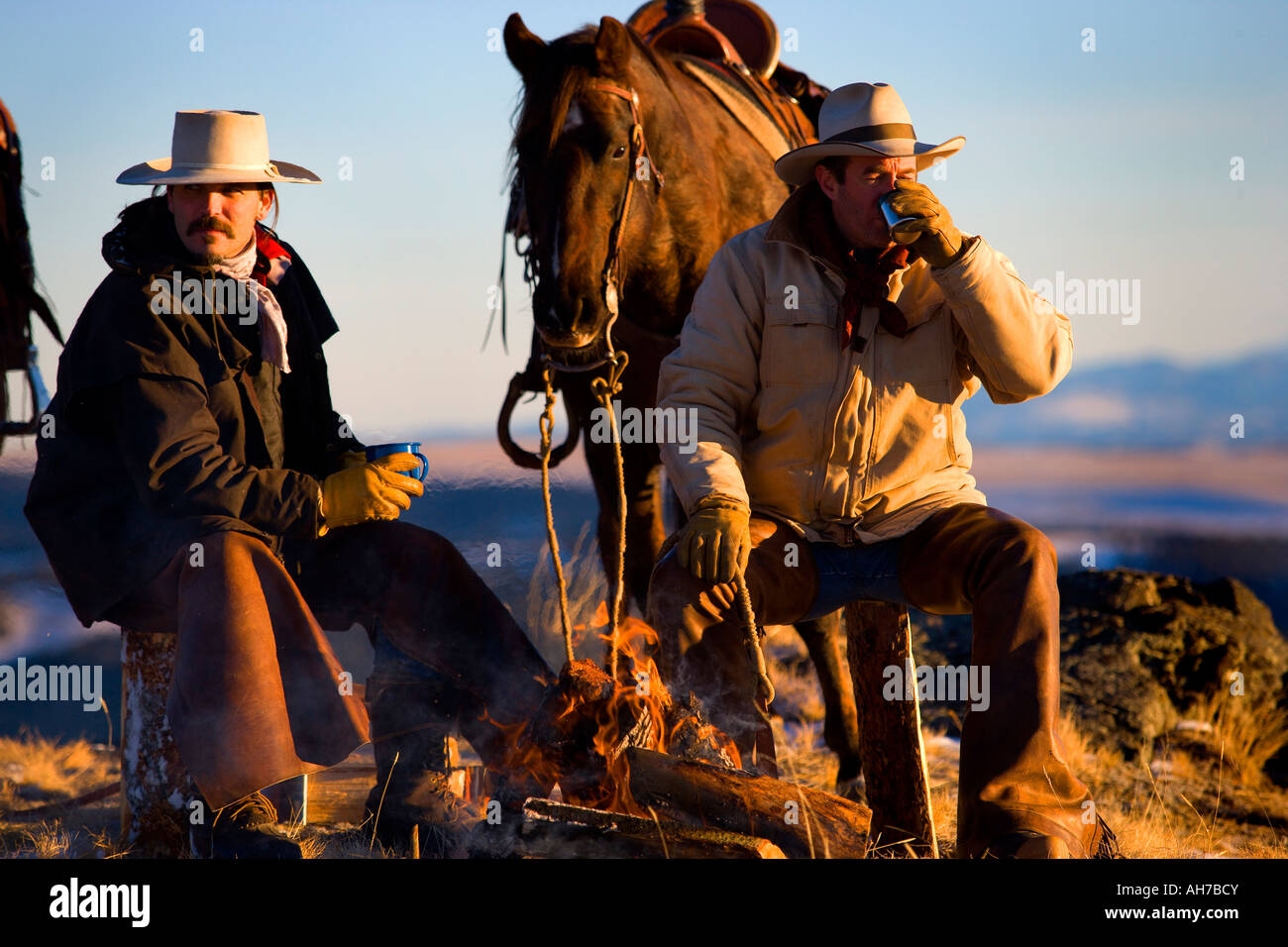 Due uomini seduti davanti a un falò Foto Stock