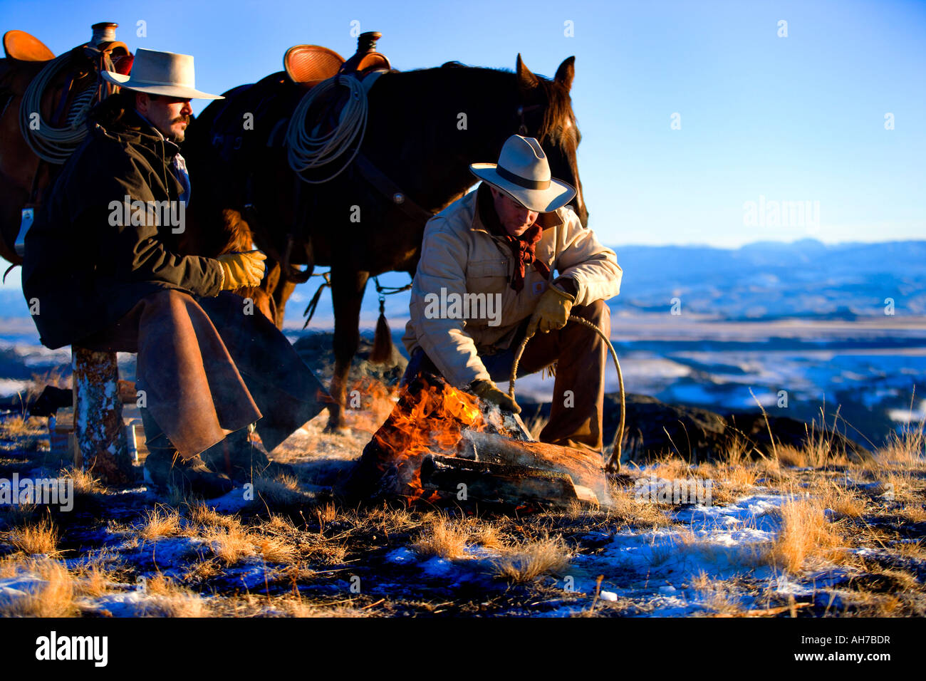 Due uomini seduti davanti a un falò Foto Stock