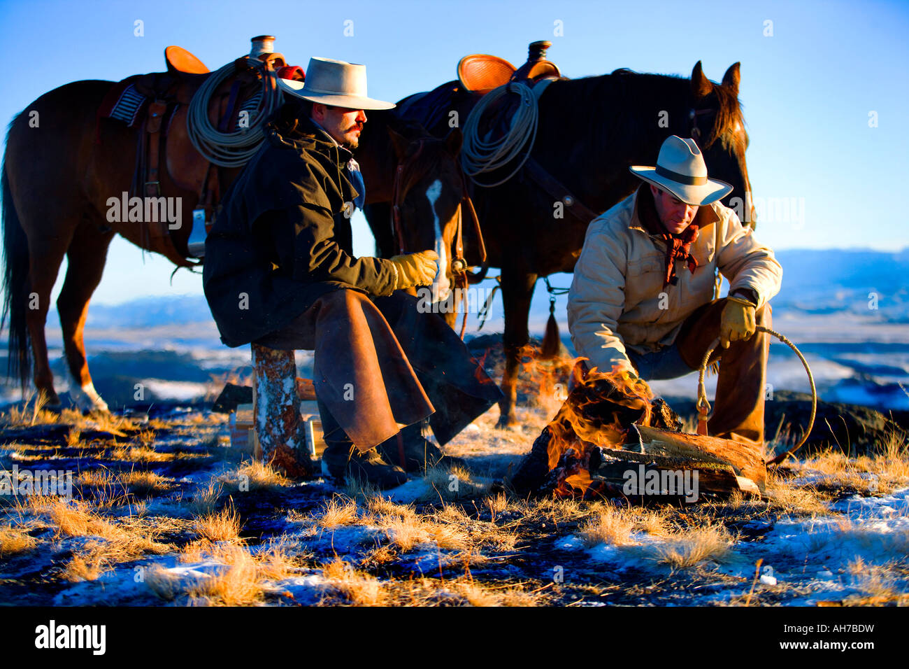 Due uomini seduti davanti a un falò Foto Stock