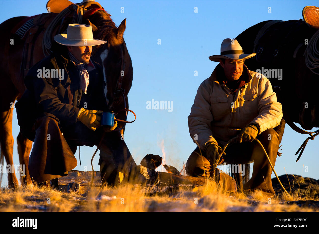 Due uomini seduti davanti a un falò Foto Stock